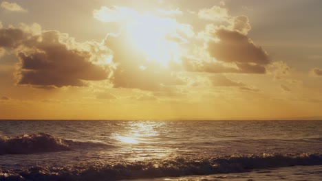 sun shinning behind the clouds at the beach