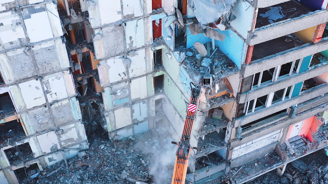 Aerial view of destruction by machine. Excavator demolition constructions.