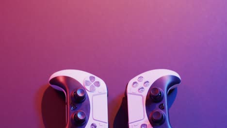 Video-of-close-up-of-video-game-pad-controllers-with-copy-space-on-neon-background