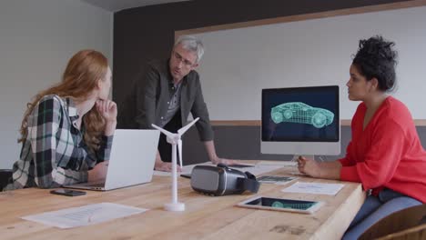 two women and a man working in a creative office