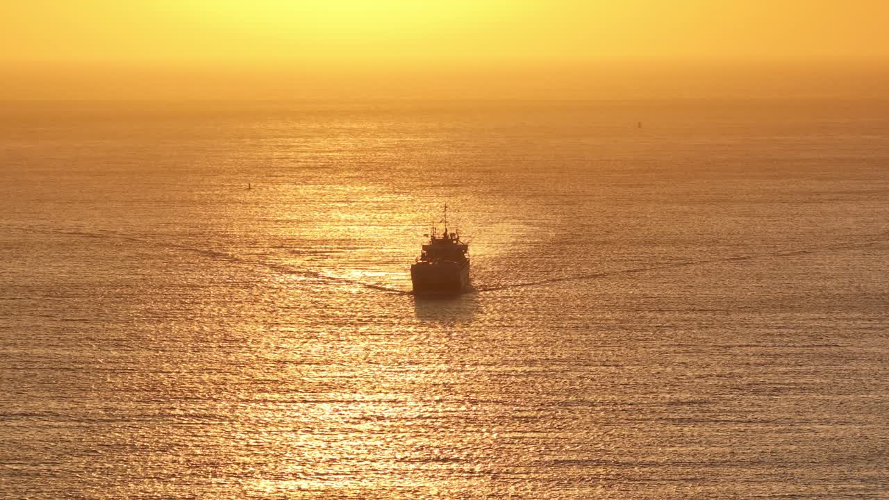 황금색 오렌지색 해가 지는 하늘과 함께 zoutelande에서 항해하는 선박의 실루 ⁇ 의 공중 뷰