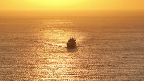 aerial view of silhouette of ship sailing off zoutelande with golden orange sunset sky