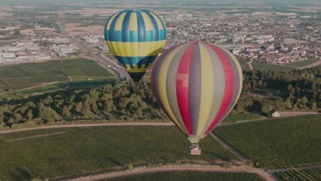 4k aerial hot air balloons very close to each other above vineyards