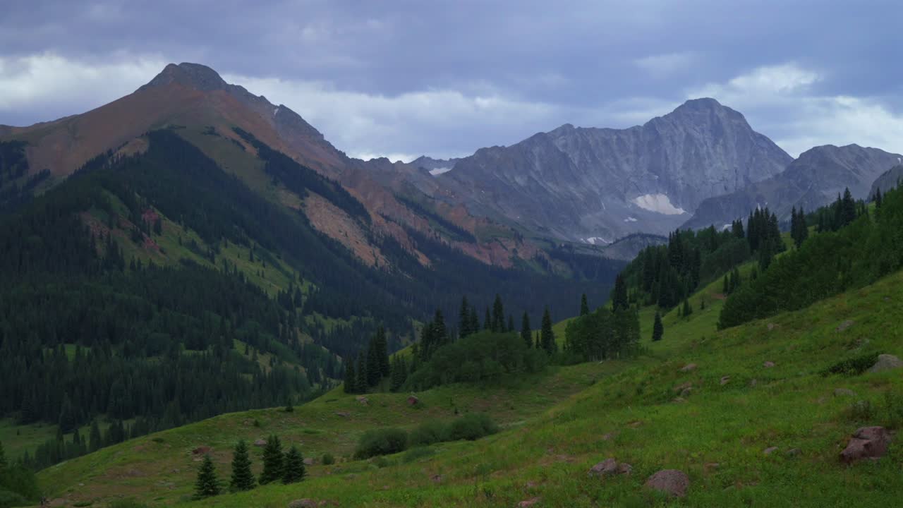 Capitol Peak wilderness trailhead aerial drone view Colorado cloudy afternoon grey skies wind summer hiking trails Rocky Mountains scenic landscape view Elk Range Aspen Trees valley static