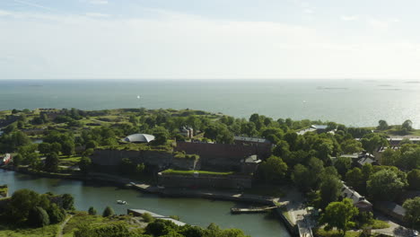 aerial view overlooking the susisaari island, at the suomenlinna fortress, sunny, summer day, in helsinki, finland - tracking, pan, drone shot