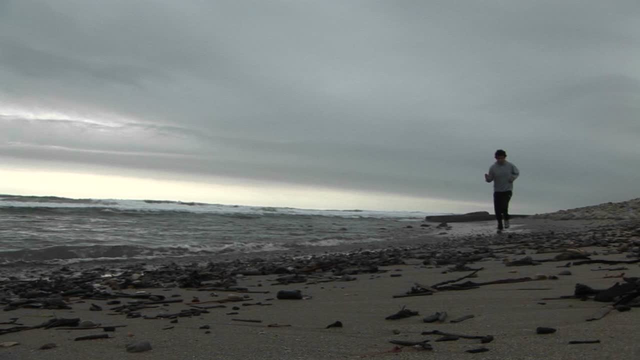 조깅하는 사람이 해변에서 뛰다