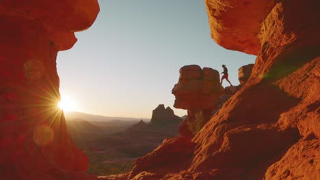 young woman walks onto insane rock outcropping to watch the sun set in sedona