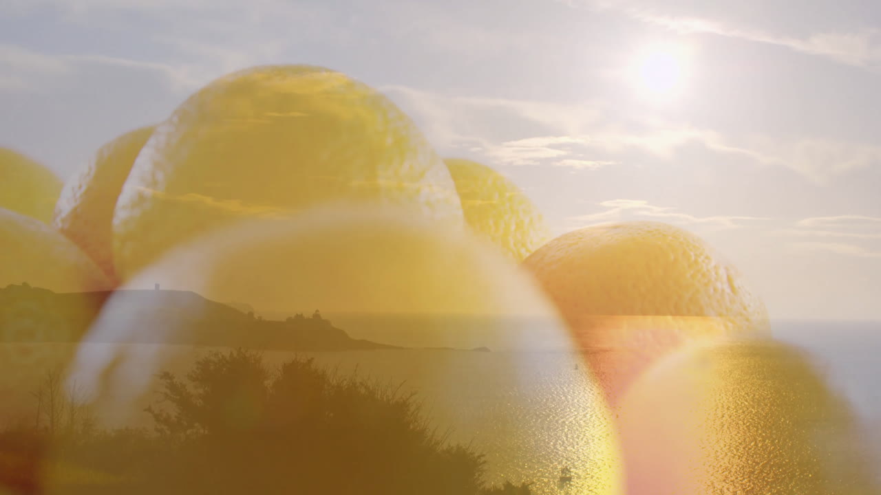 Translucent lemons creating dreamy effect over ocean landscape at sunset