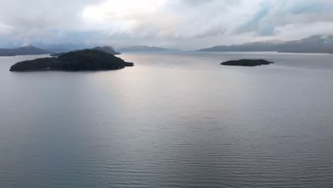 Toma-Aérea-De-Un-Lago-En-La-Patagonia-En-Un-Día-De-Invierno-Rodeado-De-Montañas