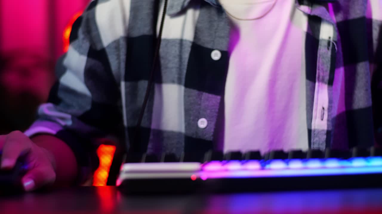 de cerca de vista delantera emocionado asiático adolescente jugador jugando videojuegos en la computadora