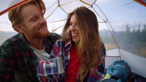 Hikers-couple-sitting-in-tent-during-camping