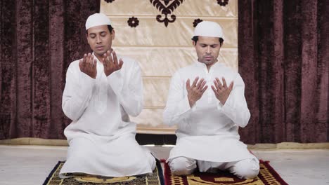 hombres musulmanes que leen las oraciones de namaz en casa