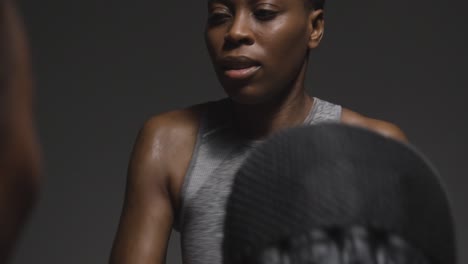 studio shot of woman wearing boxing gloves sparring with trainer 1