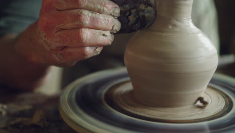 artisan shaping a vase on a pottery wheel