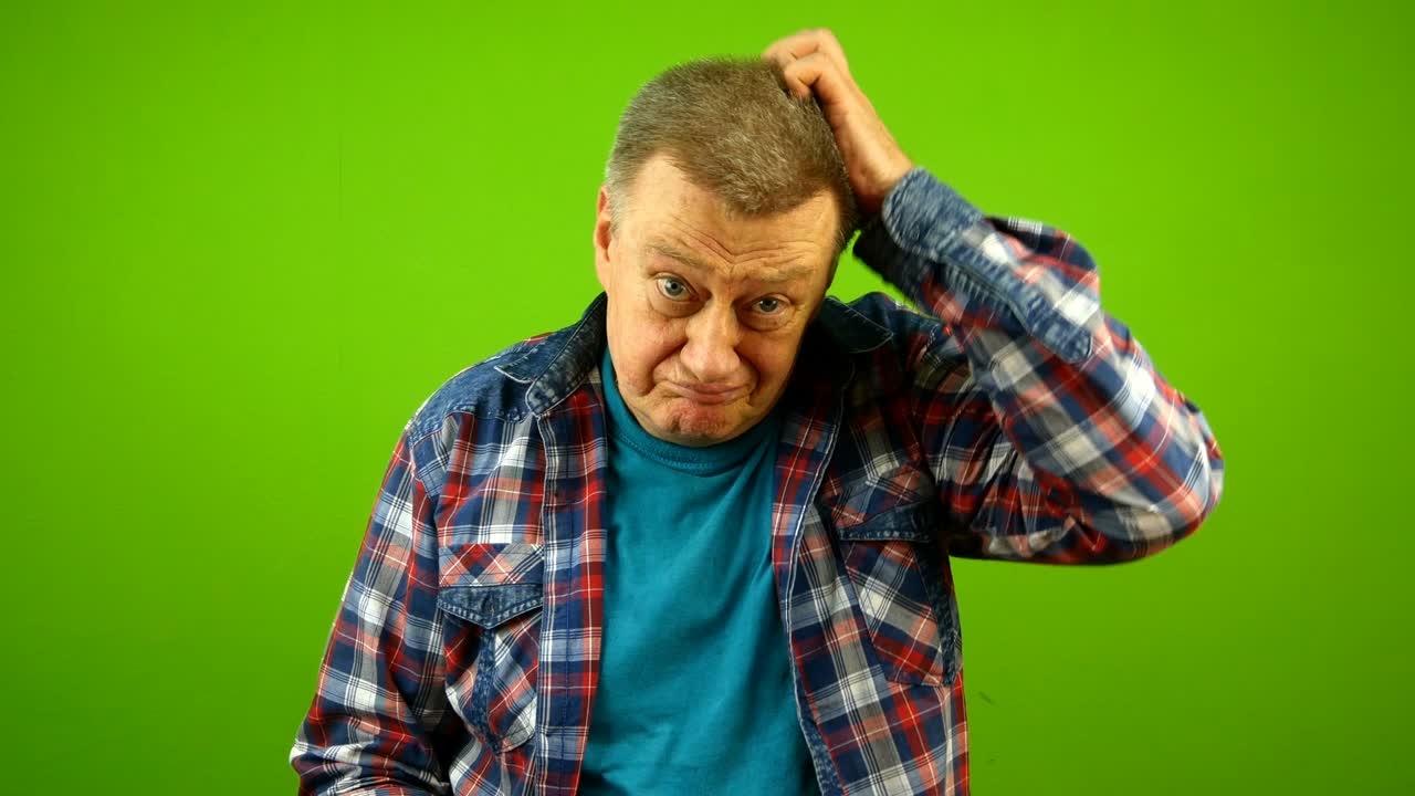 Confused puzzled, bewildered senior caucasian man in checkered shirt shrugging shoulders uncertain expression and scratching his head.