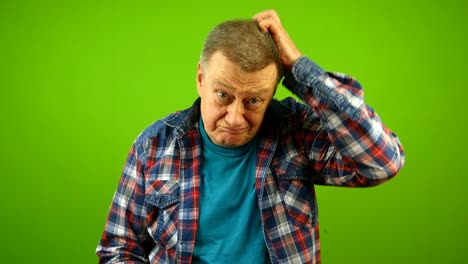 confused puzzled, bewildered senior caucasian man in checkered shirt shrugging shoulders uncertain expression and scratching his head.