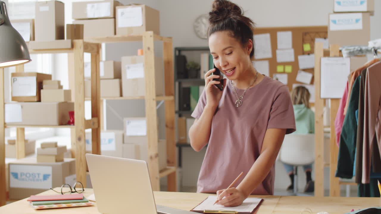 mujer hablando por teléfono y trabajando en un pequeño negocio