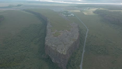 Majestic-grand-Eyjan-rock-island-in-Asbyrgi-canyon,-scenic-Iceland-landscape,-aerial