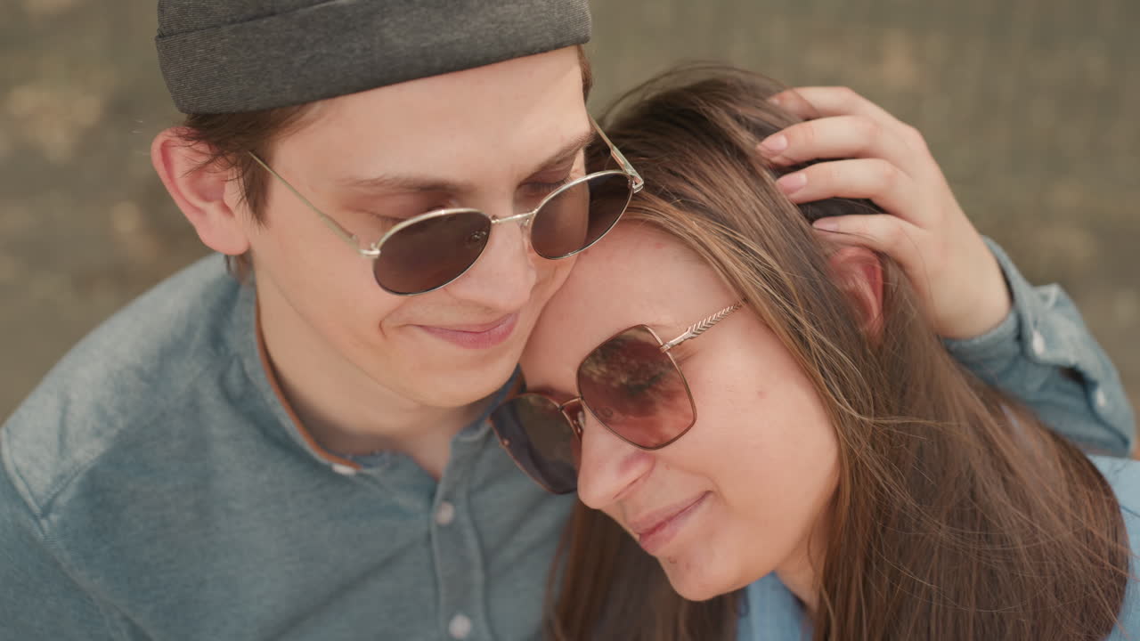 Pareja despreocupada disfrutando de un cálido día soleado, par de enamorados compartiendo sonrisas y caricias suaves al aire libre durante el verano, dúo entusiasta disfrutando del sol con gestos divertidos y energía alegre