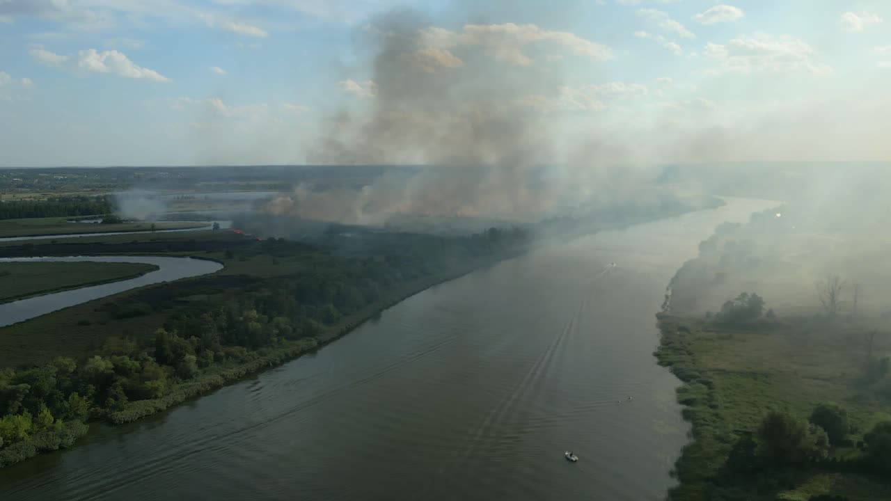 Smoke rises from a large wildfire along the Odra River in Szczecin, Poland on a clear sunny day