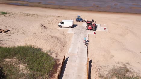 aerial view of repair works along the baltic sea coast, featuring visible construction machinery and a concrete footbridge