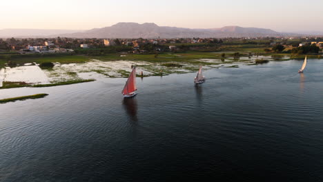 traditional boat gliding along nile in luxor - aerial