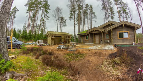 Proceso-De-Construcción-De-Casas-De-Madera-En-Una-Zona-Forestal,-Lapso-De-Tiempo-De-Camionetas-Y-Materiales-De-Construcción