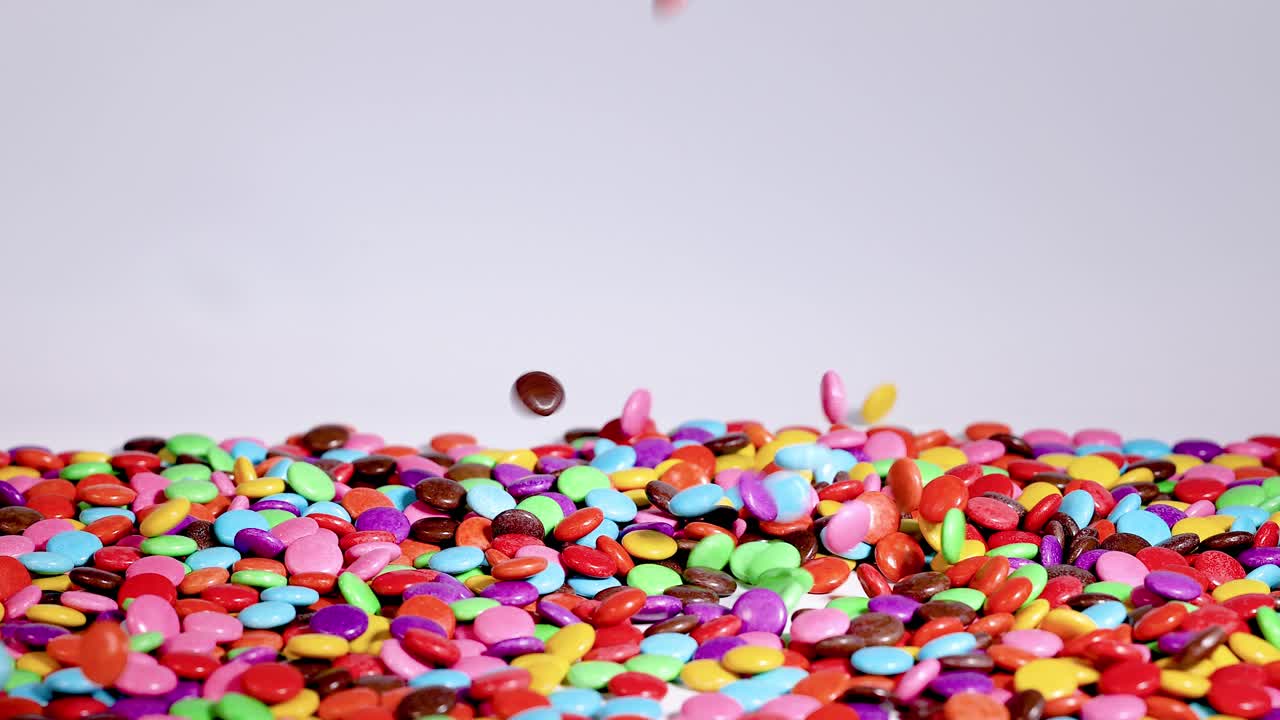 los caramelos vibrantes caen en cascada sobre una pila creciente