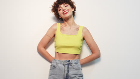 smiling woman in yellow crop top and jeans