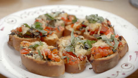 plato de pan tostado con tomate, queso, laurel y aceite de oliva