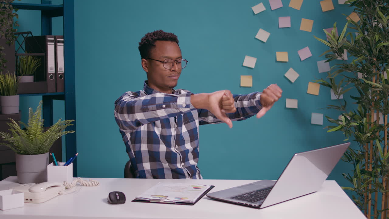 Sales specialist doing thumbs down gesture in front of laptop screen