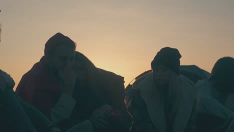 group of friends in camp on meadow at sunset slow motion