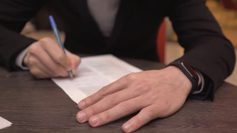 hombre de negocios tomando notas o firmando contratos, bolígrafo y documento, hombre con chaqueta formal. mano cerca