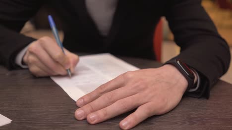 businessman taking notes or signing contract, pen and document, man in formal jacket. close up hand