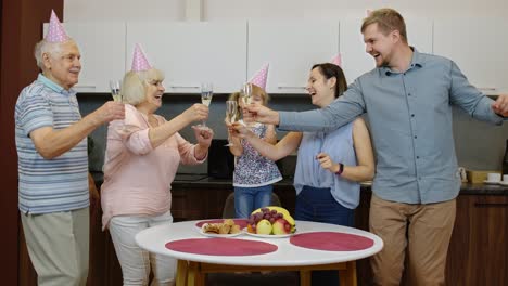 family celebrating a birthday with champagne and cake