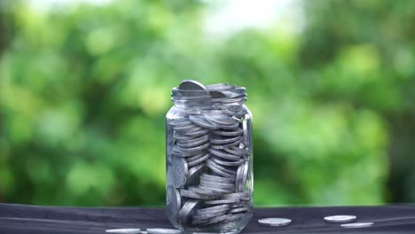 fill coins in a glass jar until it is full and overflowing