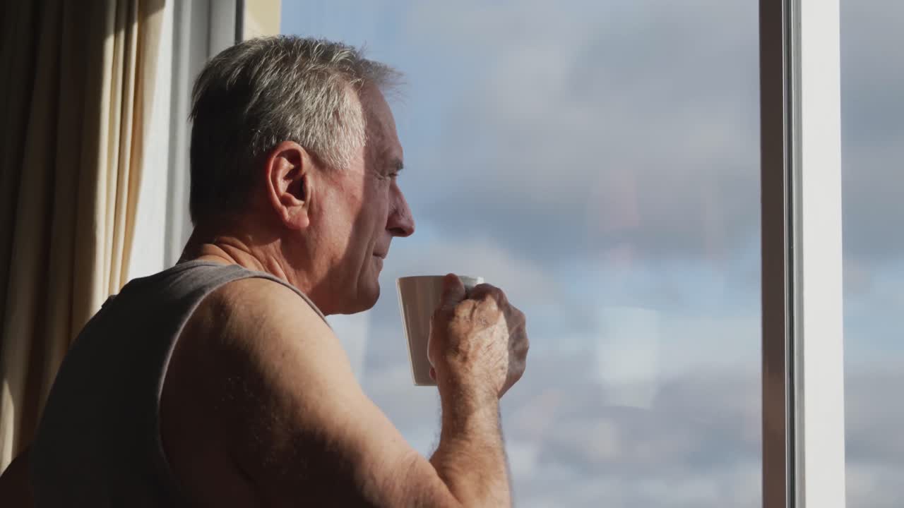 창문 근처에서 커피를 마시는 노인