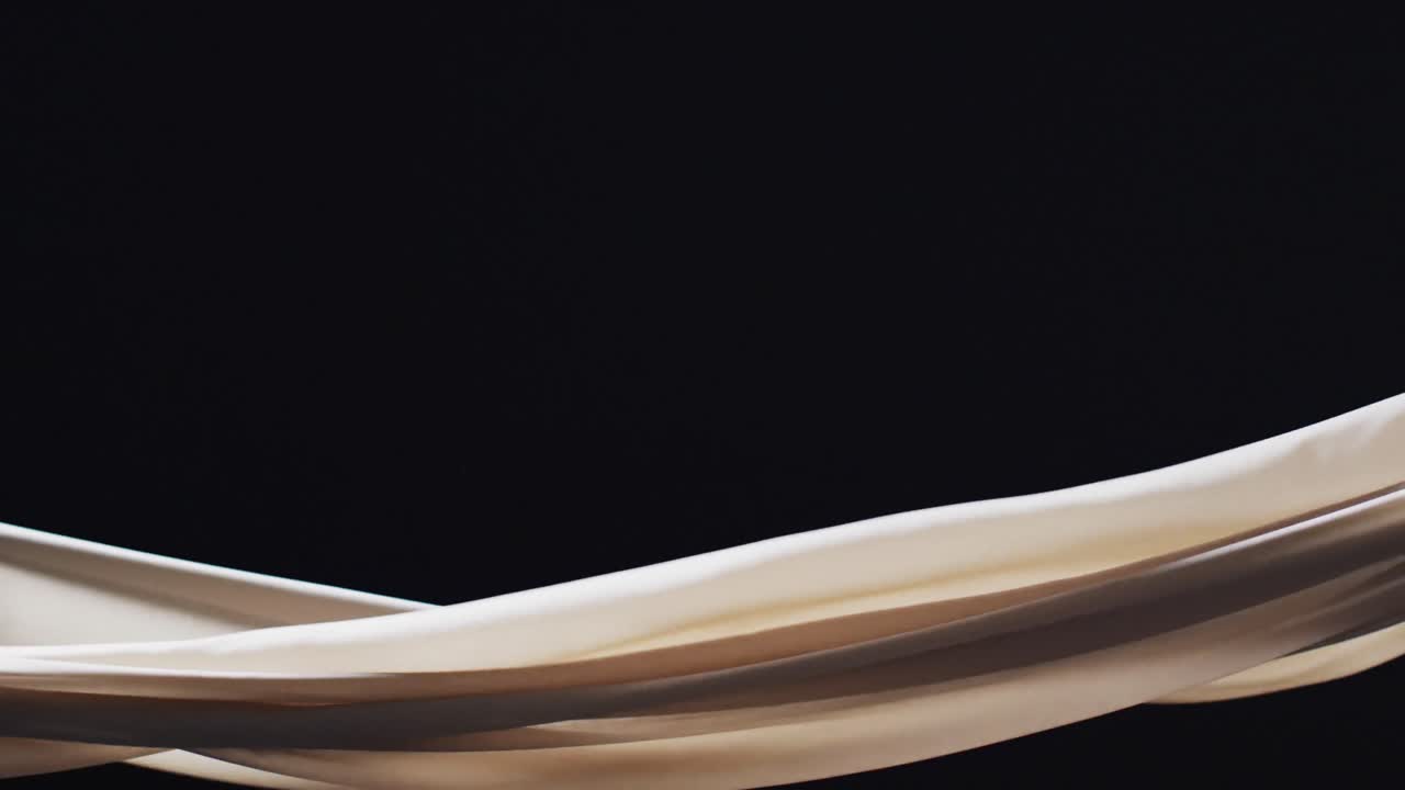 검은색 배경 위에 복사 공간과 함께  ⁇ 색 천을 불어 넣는 애니메이션