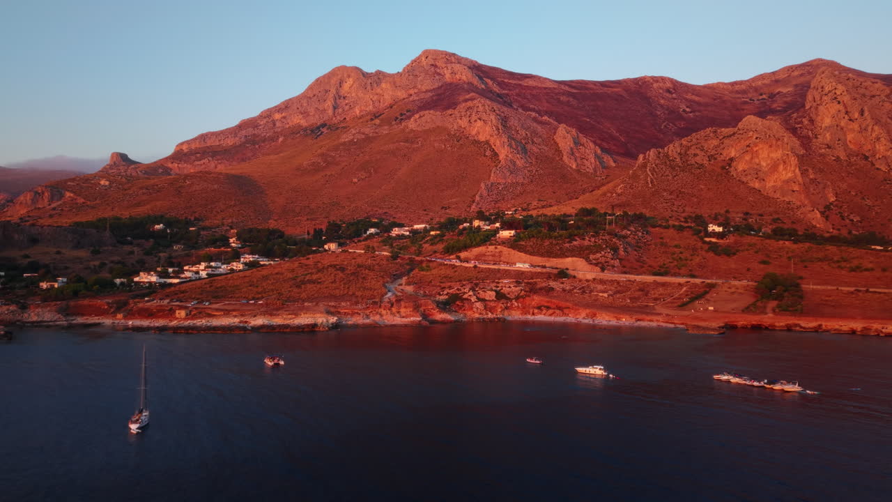 Serene sunset over Sicily's coastal mountains and calm blue sea