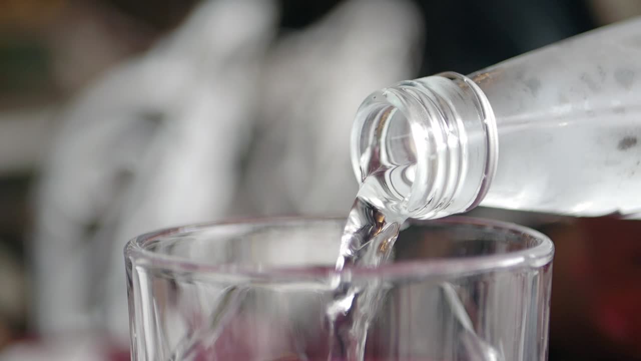 vertiendo agua de una botella en un vaso