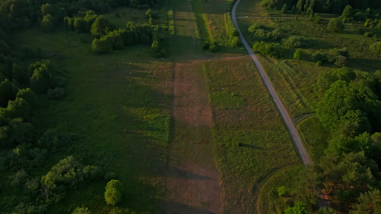 Fields, trees and a winding country road in rural Estonian nature