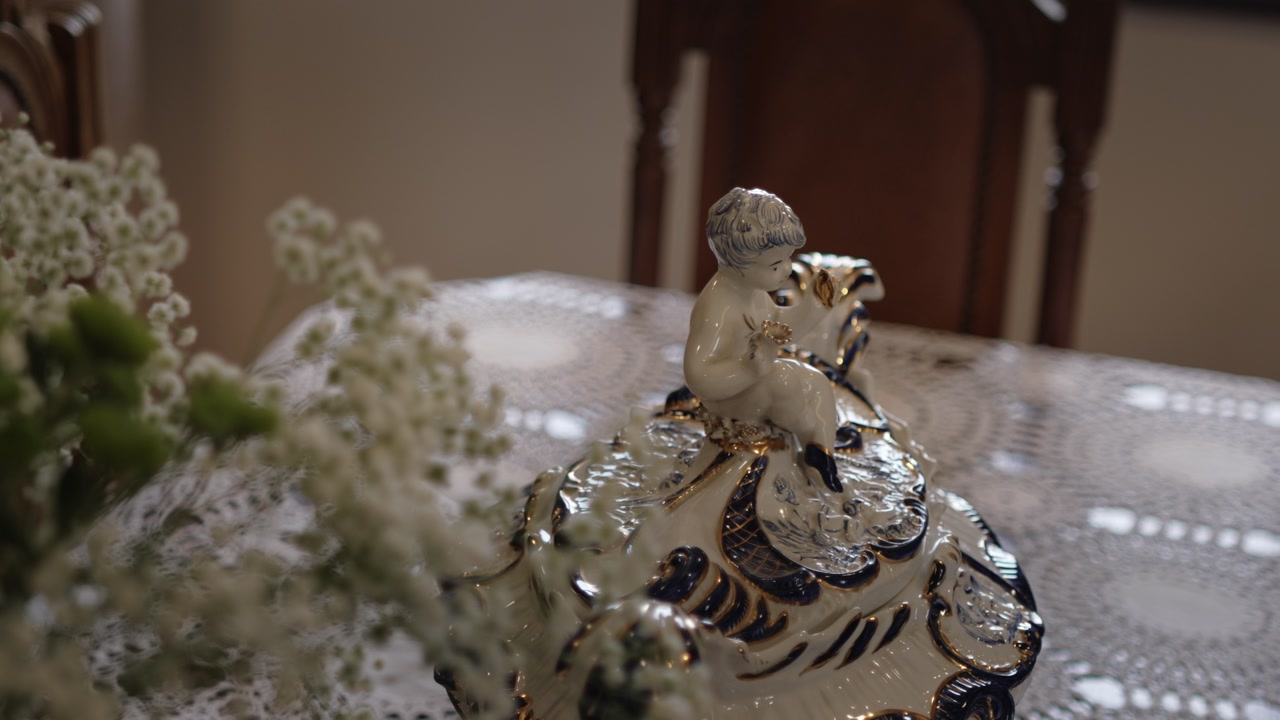Elegant porcelain figurine of a child displayed on a lace-covered wooden table