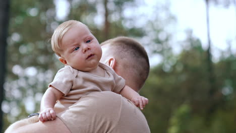 father carrying baby outdoors