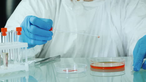 hombre haciendo un examen microbiológico de muestras en un laboratorio con una placa de petri