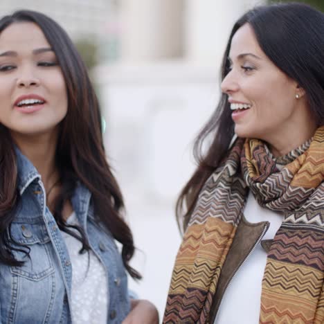 two stylish women chatting outdoors in a town