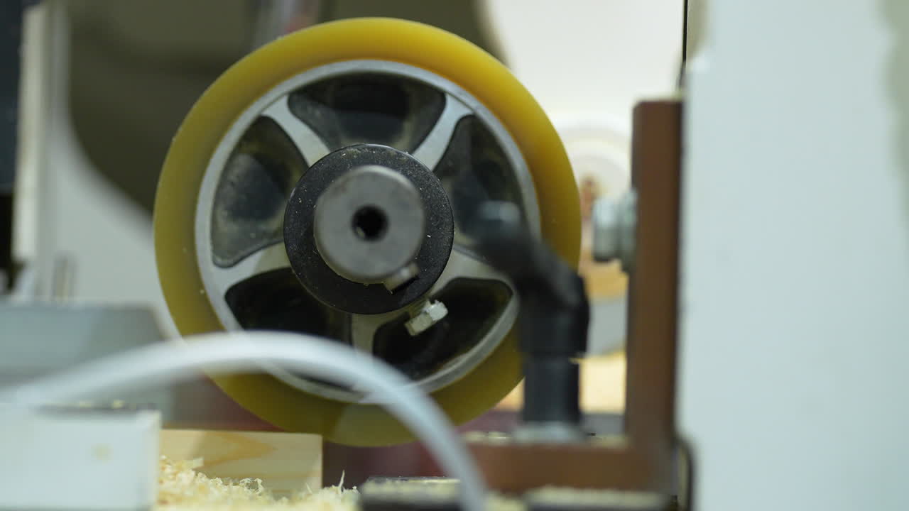 Primer plano de un rodillo de alimentación giratorio en una máquina profesional para trabajar la madera. Ideal para fabricación industrial, procesamiento de madera y contenido para talleres de artesanía.