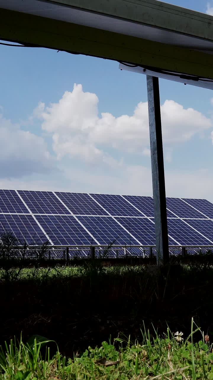 Constructions for the installation of solar panels on the ground. Cells of photovoltaic panels. Solar power plant in the field. Vertical video