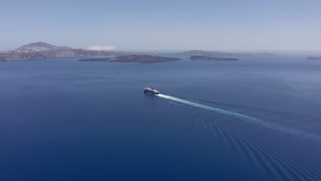 aerial: one ferry boat sails to santorini, greece on a sunny day