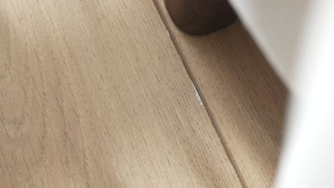 person finding a sim card on a wooden floor