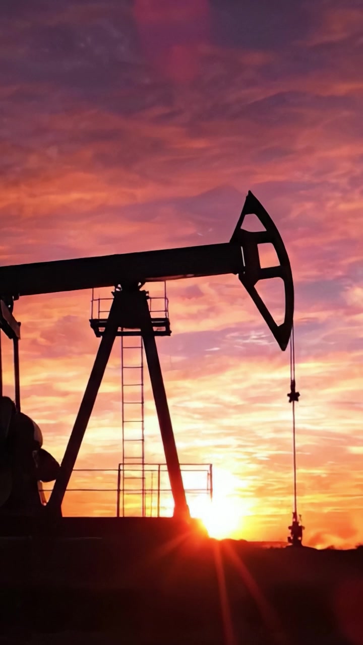 Transformative Energy at Dusk: A Silhouetted Oil Pump Jack Against a Breathtaking Sunset Glow